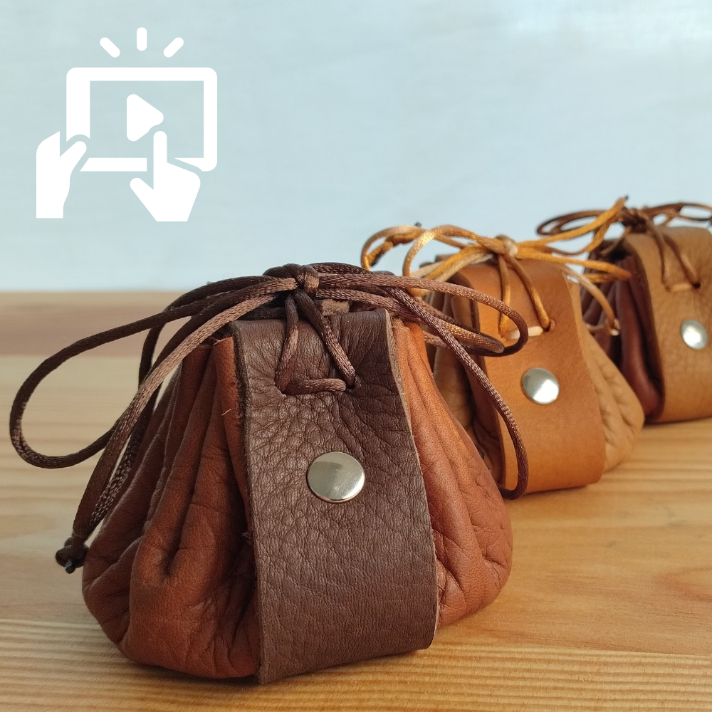Three brown leather drawstring bags on a wooden surface with a light blue background.